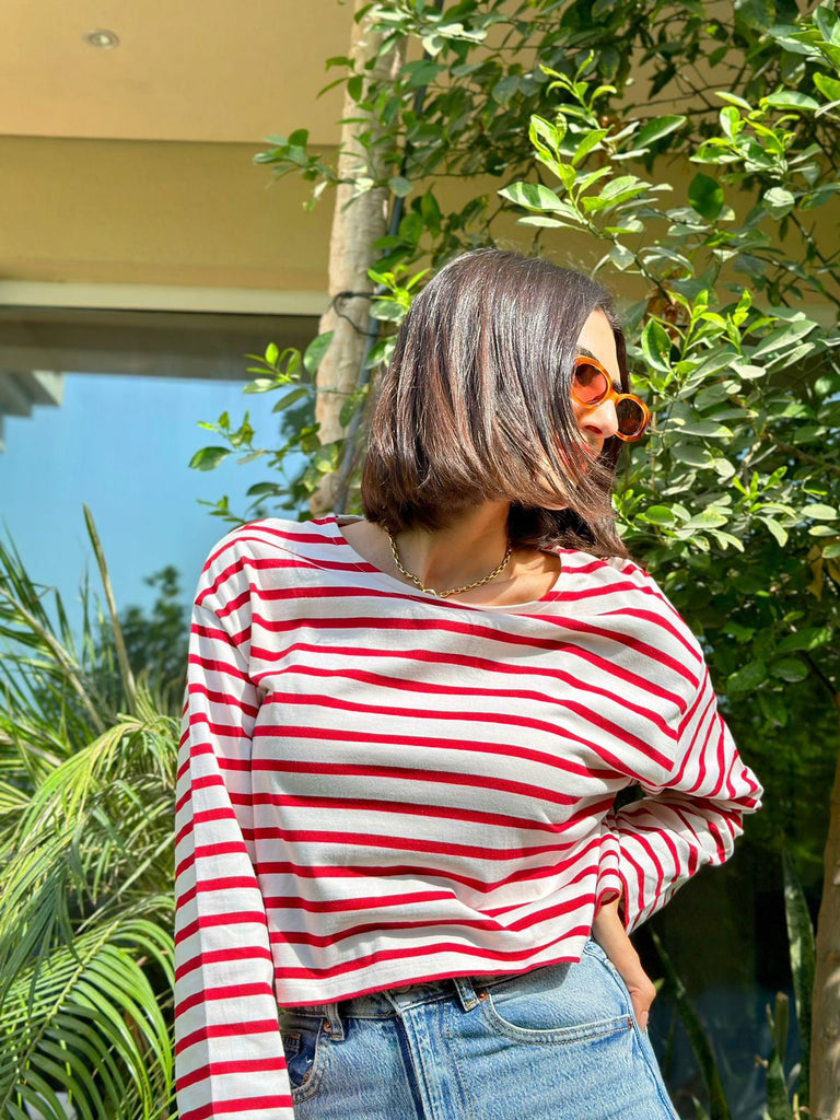 Model Rima Zahran wearing red stripe top and sunglasses posing in the sun
